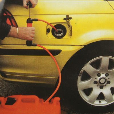 Siphon hose connected to a car opening with black nozzle and red tubing