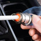 Hand inserting cigarette lighter plug into car socket with glowing heating tip