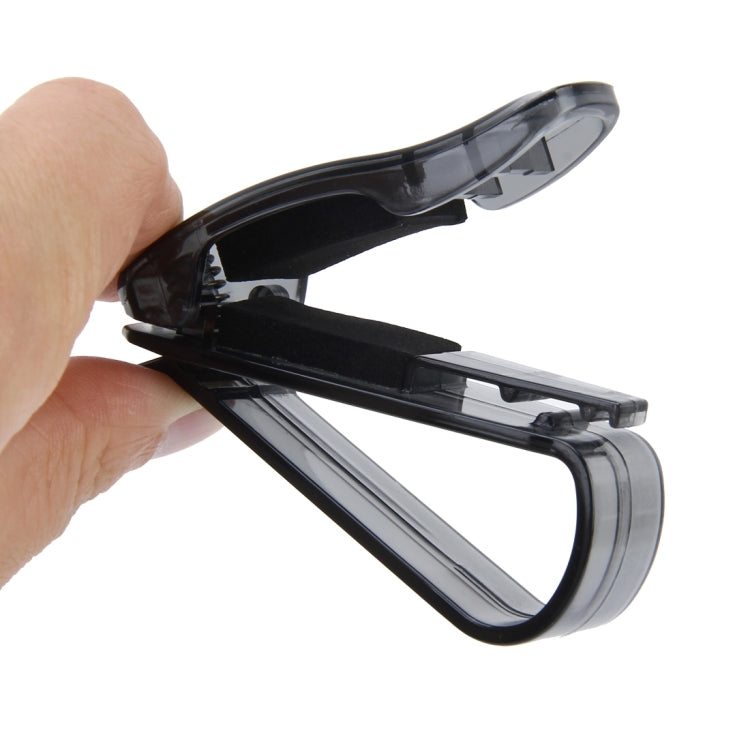 Black sunglass and card clip held in hand, open clamp with spring bars