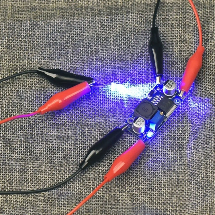 Alligator test lead clips on red/black wires connected to an electronics board