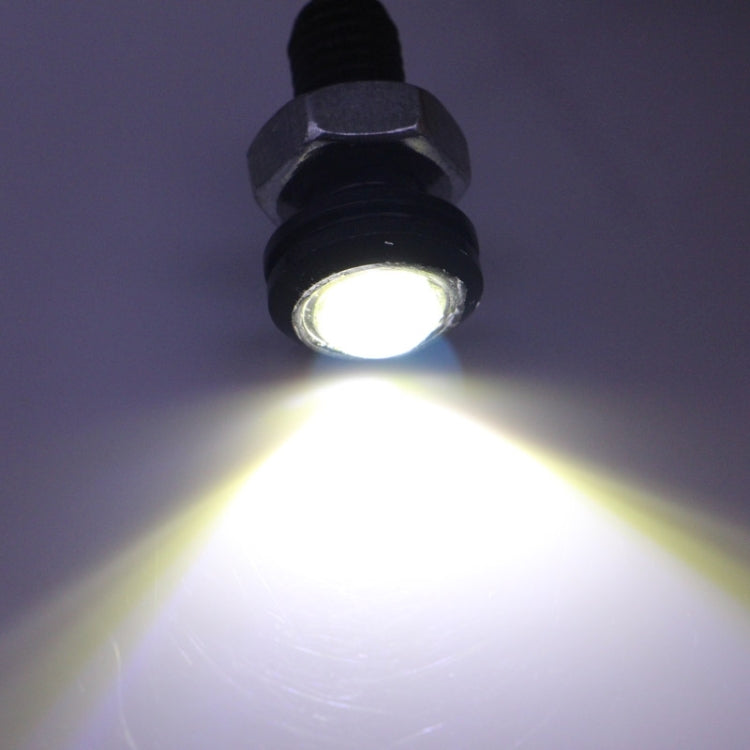 Lit LED eagle eye light bulb with black housing emitting bright white light