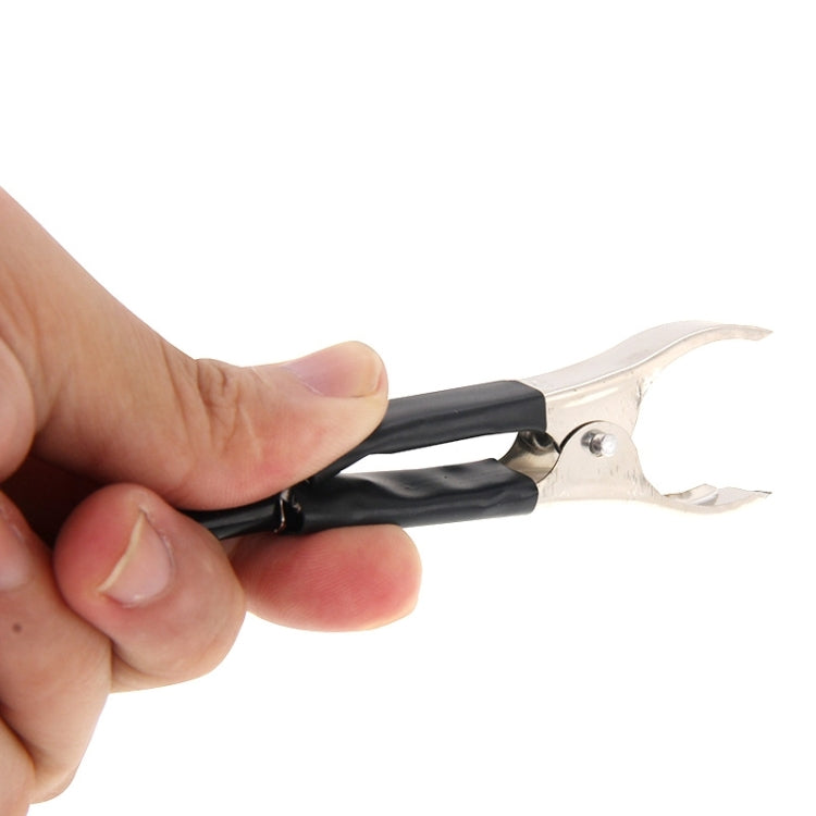 Hand holding black circuit tester clip and insulated lead wire