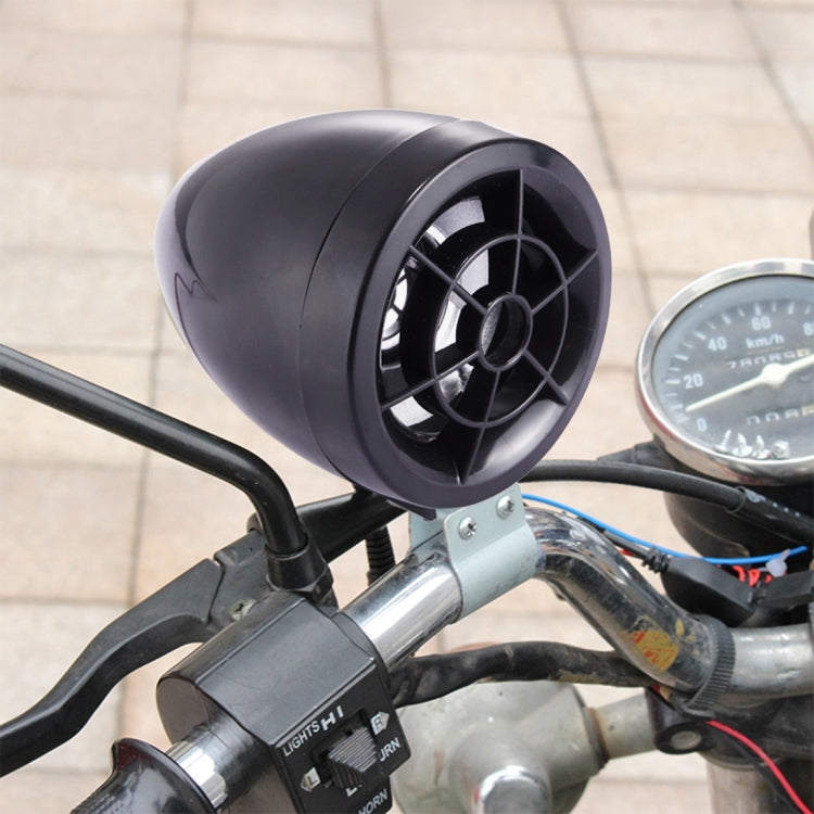 Mounted black motorcycle speaker on handlebars with connected wiring and nearby gauge