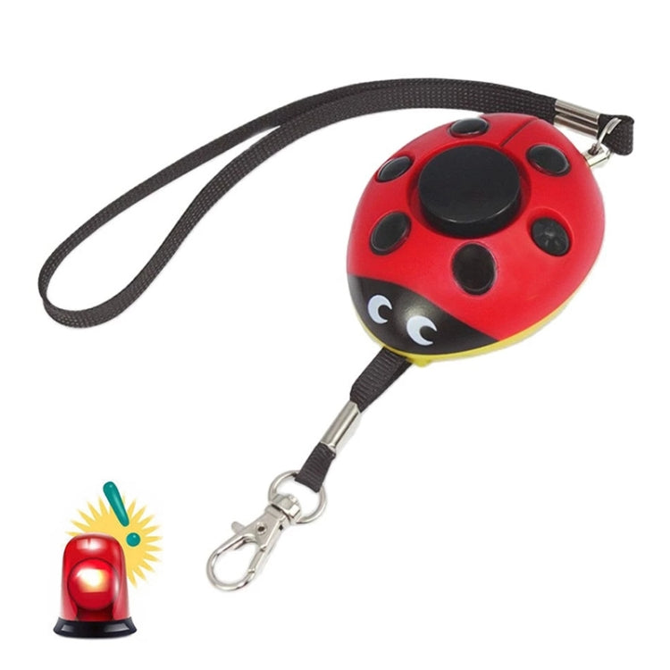Red ladybug-shaped personal alarm with black spots and wrist lanyard clip