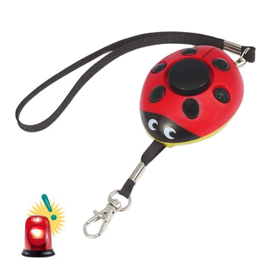 Red ladybug-shaped personal alarm with black spots and wrist lanyard clip