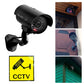 Black dummy CCTV camera with clear LED lens and red glowing indicator