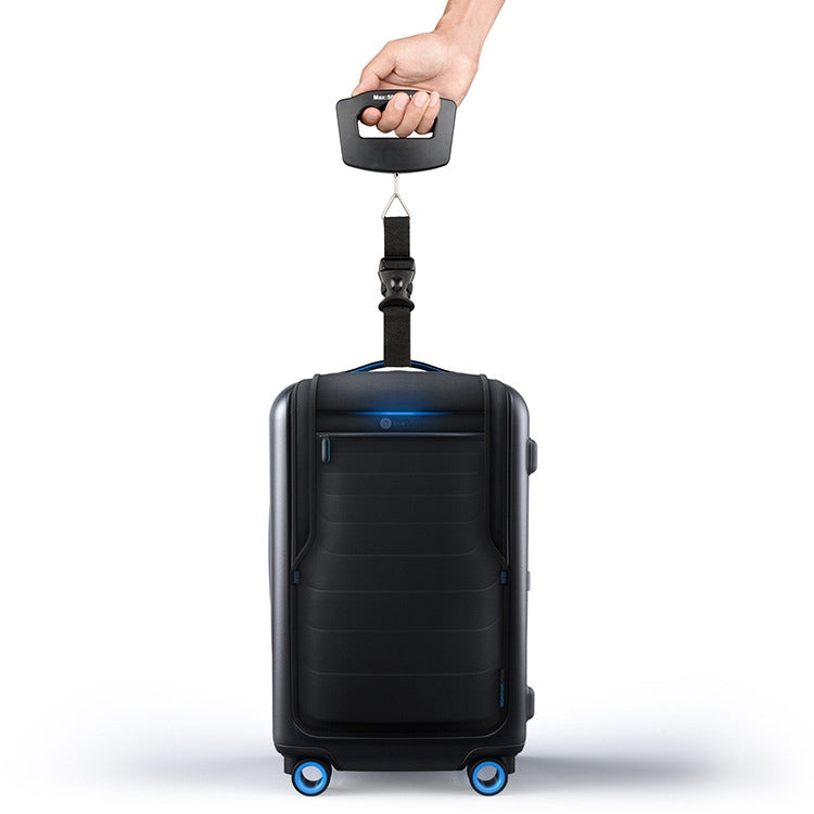 Black electronic luggage scale held by hand, strap connected to suitcase