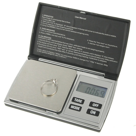 Flip-open digital pocket scale with backlit LCD screen and TARE/MODE/OFF buttons.