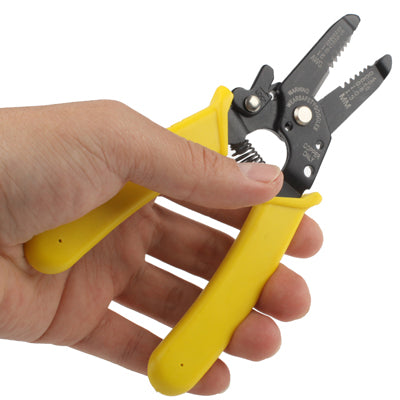 Wire stripper cutter pliers held in hand with yellow handles and black jaws