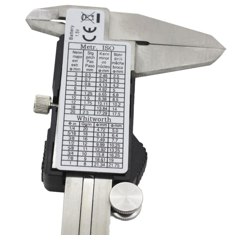 Digital LCD vernier caliper close-up, screen showing ISO conversion table