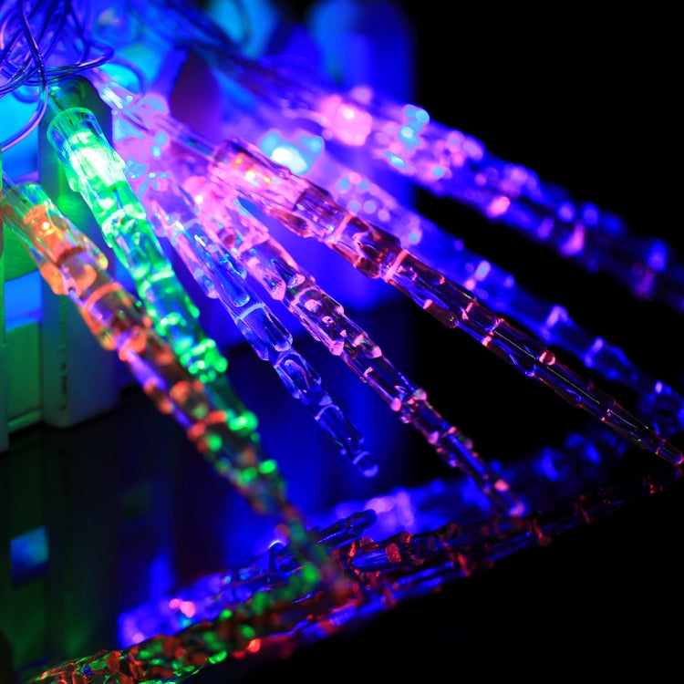 Lit multi-colored LED string lights with clear bulbs on diagonal wire strands