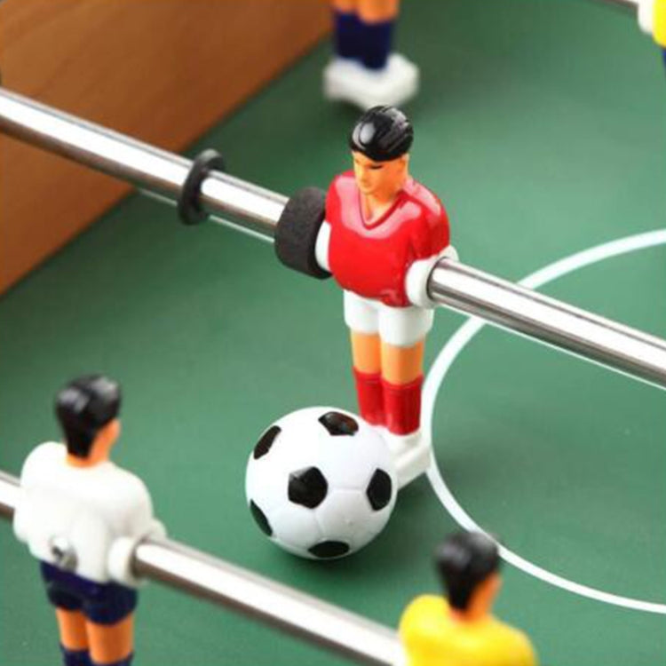 Close-up of tabletop football game players and ball on green pitch