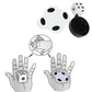Three-piece flat magic trick toy with white die, black base, and hand diagram