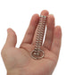 Metal ring and spring trick toy held in palm, spring coil visible