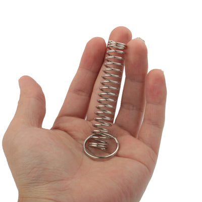 Metal ring and spring trick toy held in palm, spring coil visible
