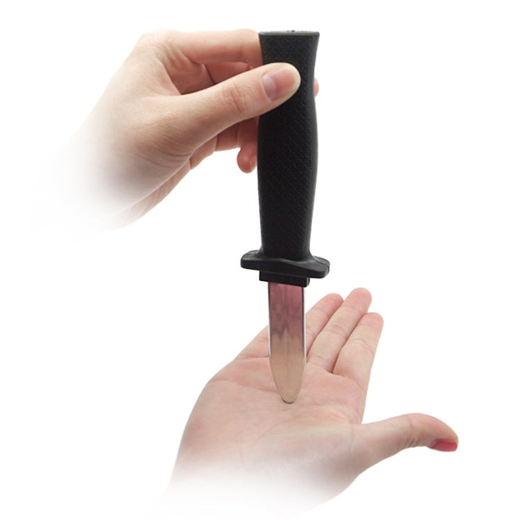 Retractable plastic gag knife held upright, black handle with blade extended