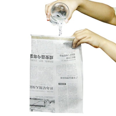 Newspaper prop with water being poured over printed pages