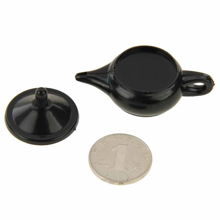 Black teapot magic prop with lid knob, coin accessory, and side handle loop