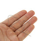 Memory metal wire laid across open palm, slender dark metal prediction prop