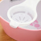 Egg yolk separator, white scoop-style holder in a bowl