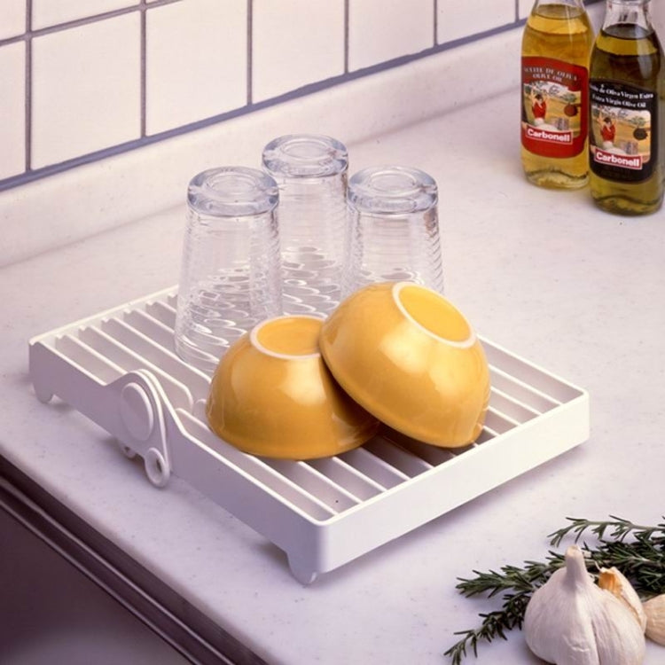 White plate drying rack holding upside-down bowls, cups, and glassware on slats