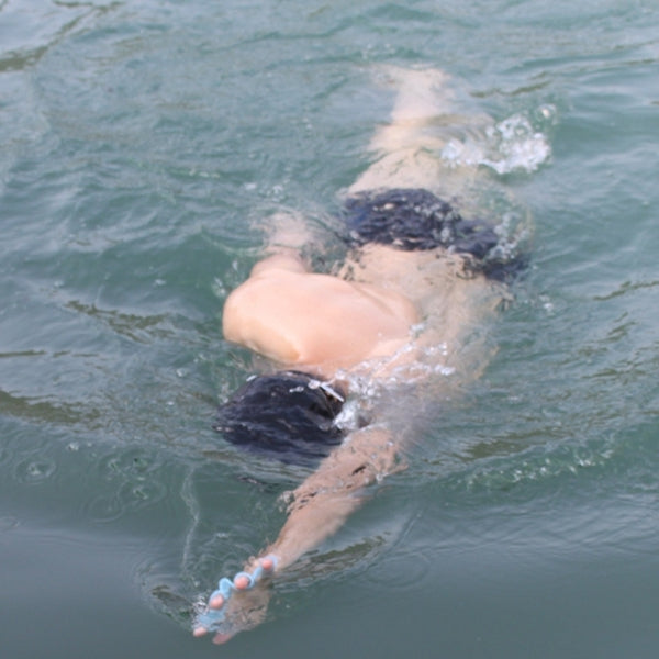 Swimmer wearing translucent light blue silicone hand flippers with webbed fin pads
