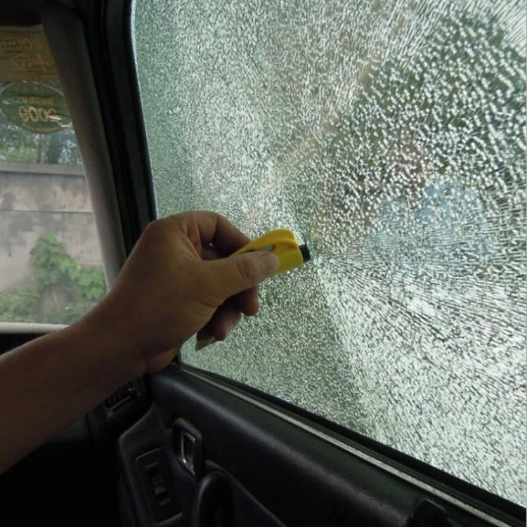 Yellow glass-break rescue tool used against car window by hand