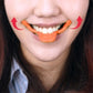 Person wearing an orange smile maker tool around the mouth for a wider smile