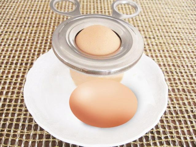 Boiled egg shell cutter tool placed over a hard-boiled egg on a plate
