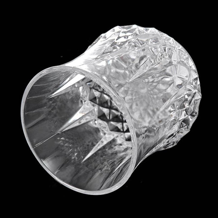 Clear faceted LED light cup shown at an angle, textured diamond pattern body