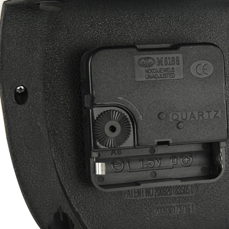 Quartz clock battery compartment and adjustment dial inside black casing
