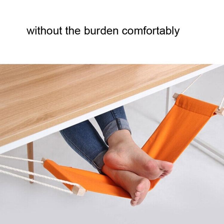 Person’s feet resting in orange foot hammock with beige straps and hanging ropes