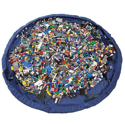 Round blue kids toy storage bag with LEGO-style blocks spread across the center