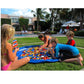 Blue kids toy storage mat bag laid on outdoor grass with toy bricks inside