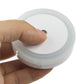 White LED night light with round button, shown being pressed by hand