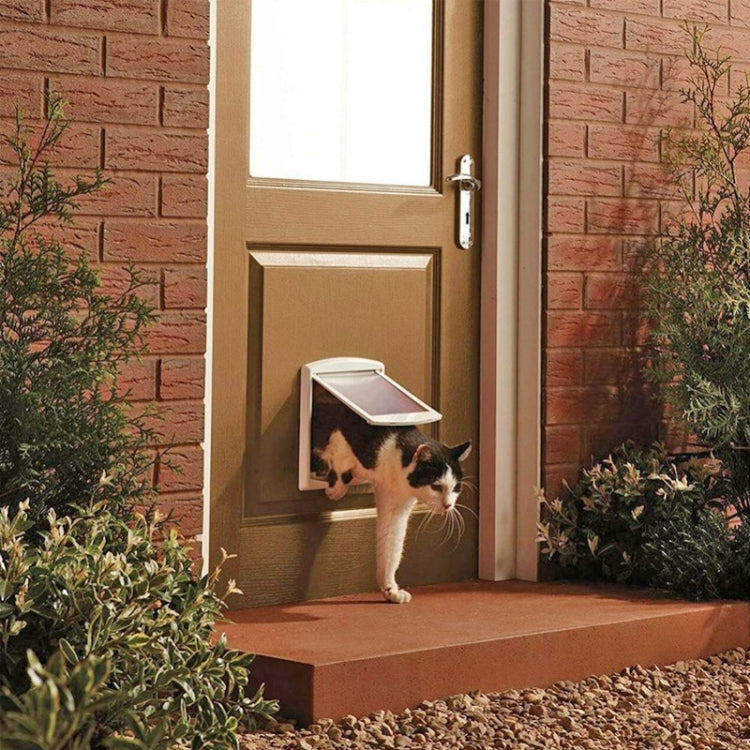 Installed white pet door with transparent flap in a house wall