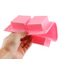 Pink silicone square cake mold with six cavities, held by hand