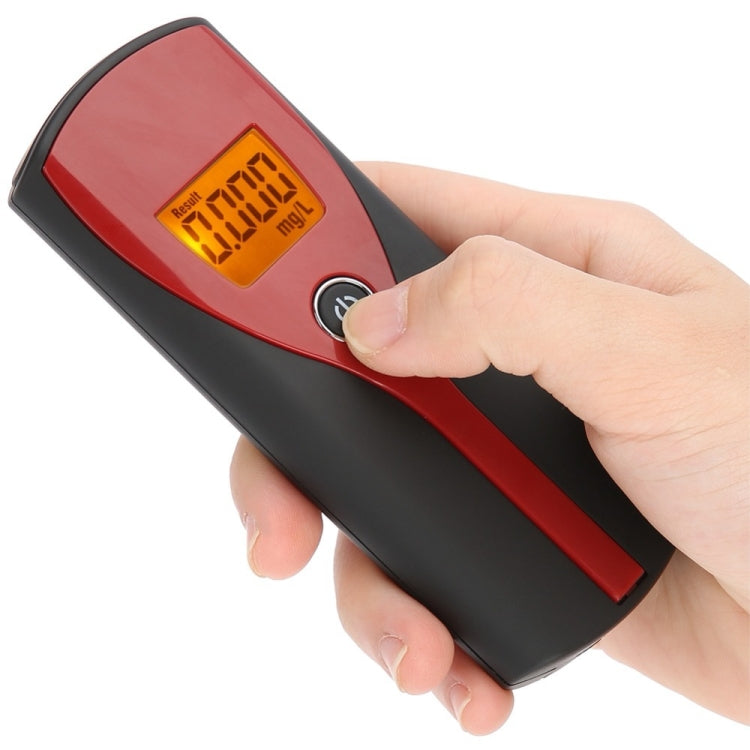 Handheld alcohol breath analyzer held in hand, orange backlit LCD result