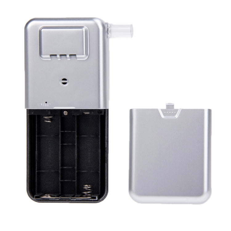 Breath alcohol tester with open battery compartment and removable back cover.