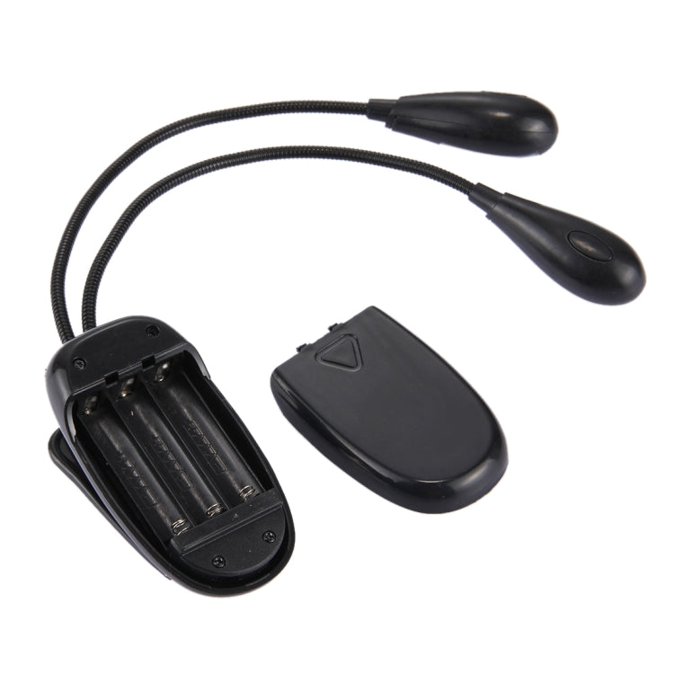 Dual-arm LED clip-on lamp with battery compartment open and power button on base