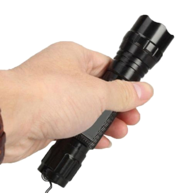 Black UV flashlight held in hand, textured grip and front lens