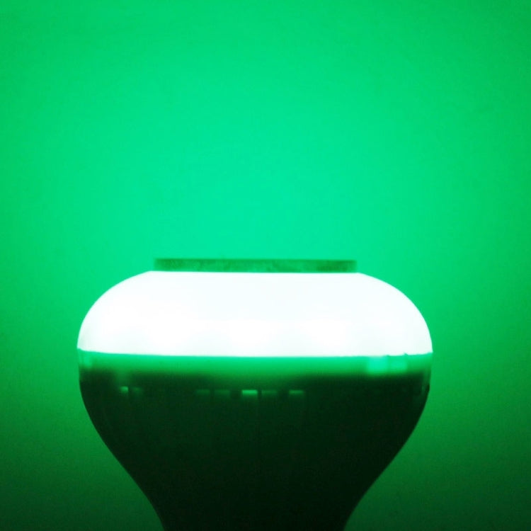 White smart LED bulb emitting green light, round diffuser glow