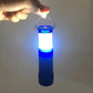 Hand holding a black LED camping lantern flashlight, glowing blue and white light