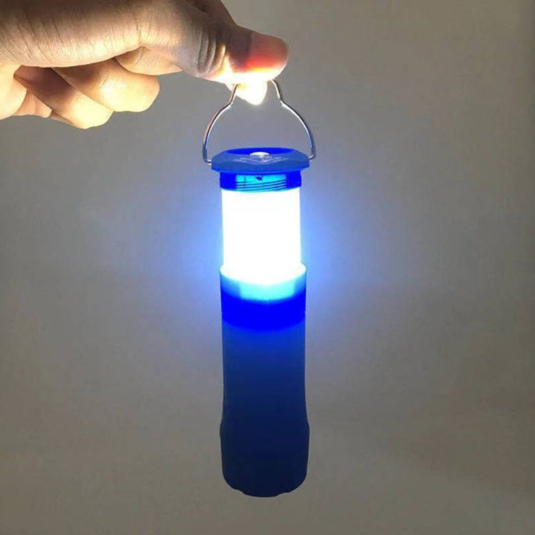 Hand holding a black LED camping lantern flashlight, glowing blue and white light
