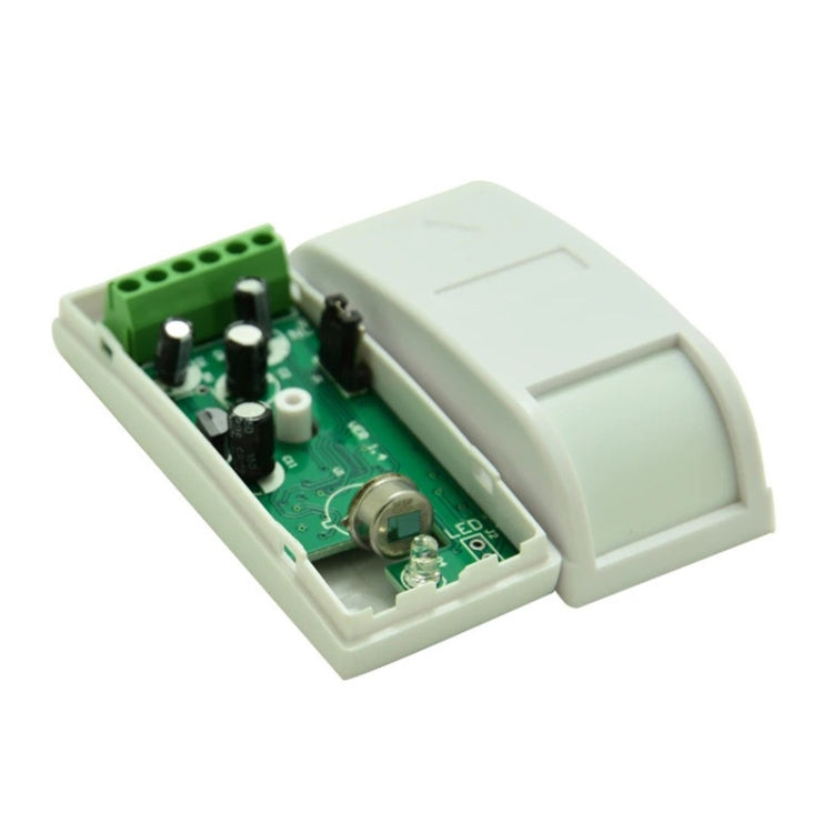 Wired PIR motion detector alarm with exposed green PCB and screw terminals, white base