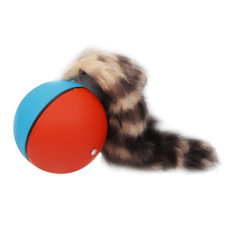 Motorized rolling chase ball toy, blue and red shell, with dog nearby