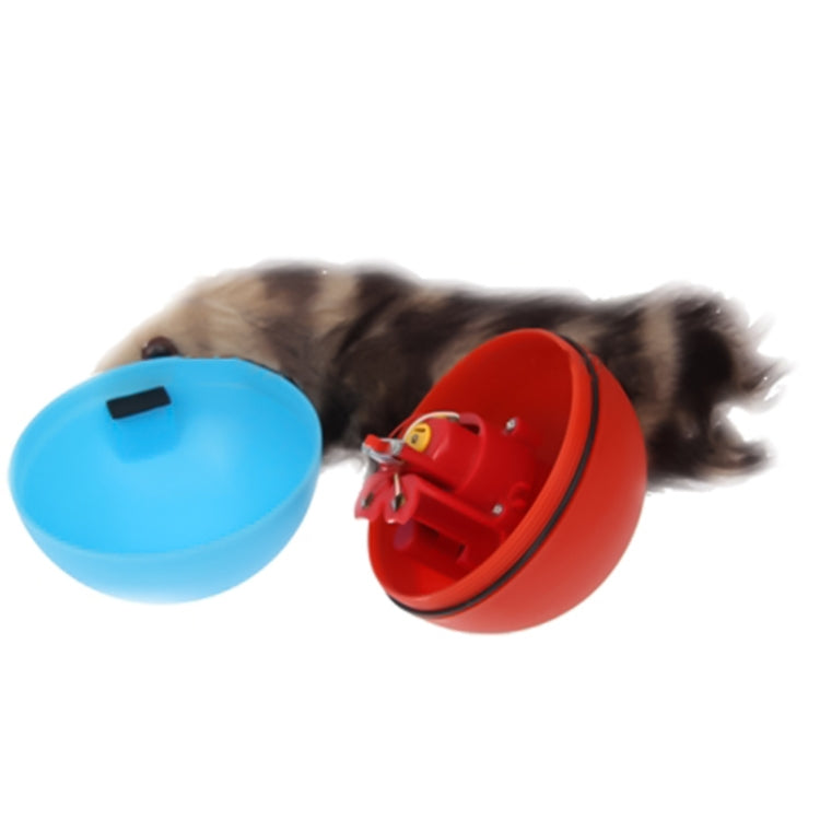 Motorized rolling chase ball toy with blue base and red underside, with dog nearby
