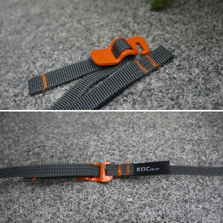 Dark gray strap with orange quick-release buckle on gray surface