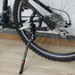 Mounted black bicycle side kickstand on front wheel with red release button