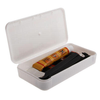 Bicycle repair kit box open with glue tube, black tire lever, and metal rasp